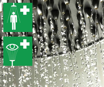 Närbild på ett duschmunstycke på en nöddusch där det strilar ner vatten ifrån. 